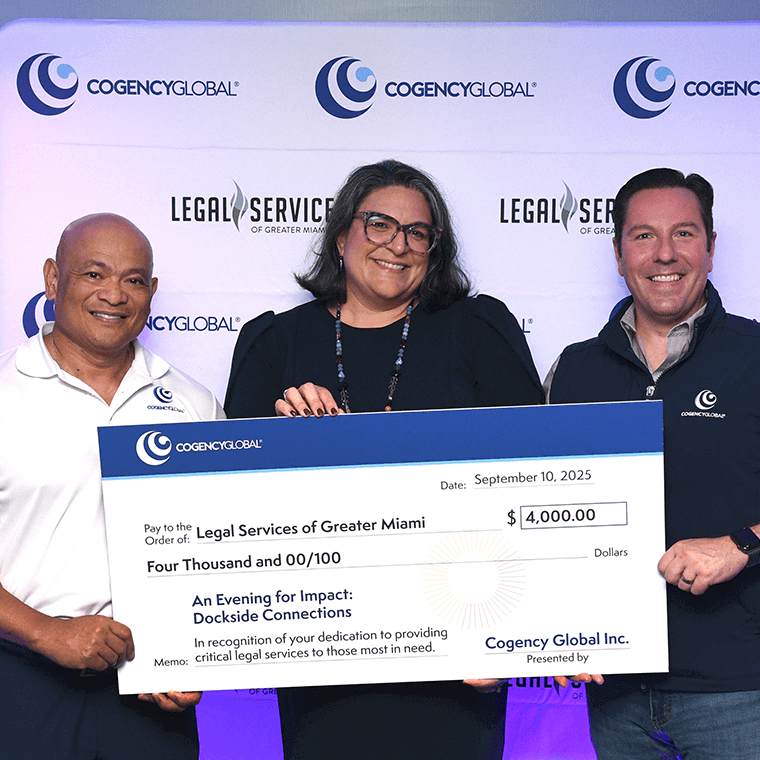 Three people smiling and holding a large check for $4,000 made out to Legal Services of Greater Miami from Cogency Global Inc., against a branded backdrop. The check is dated September 10, 2025.
